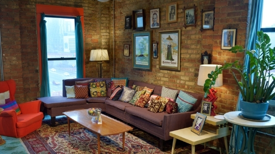 photo of an event lounge area styled with colorful and evocative art on the exposed-brick wall, all from Catalyst Ranch Event Rentals