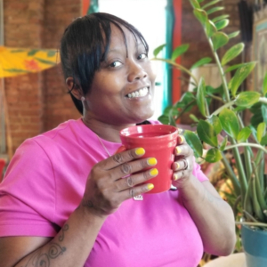 photo of Shawanda Love wearing a pink short sleeve dress, holding a red coffee mug at Catalyst Ranch